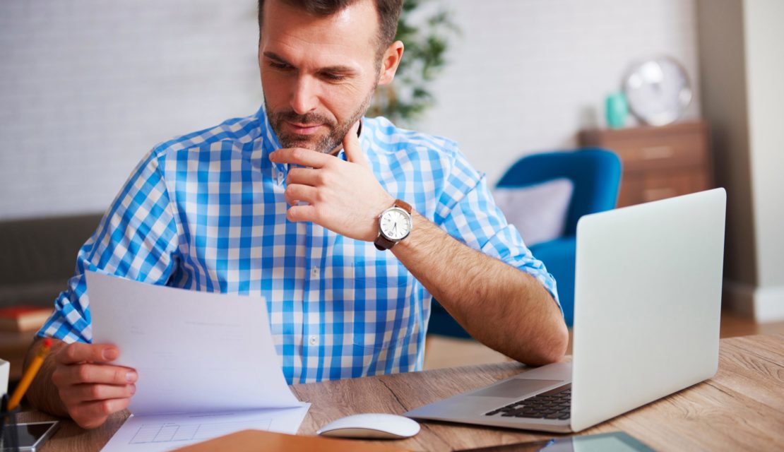 business-person-reading-important-documents-at-his-desk (1)