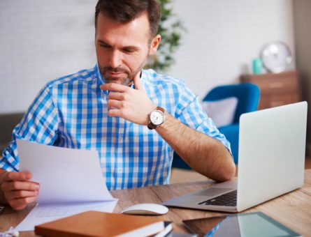 business-person-reading-important-documents-at-his-desk (1)